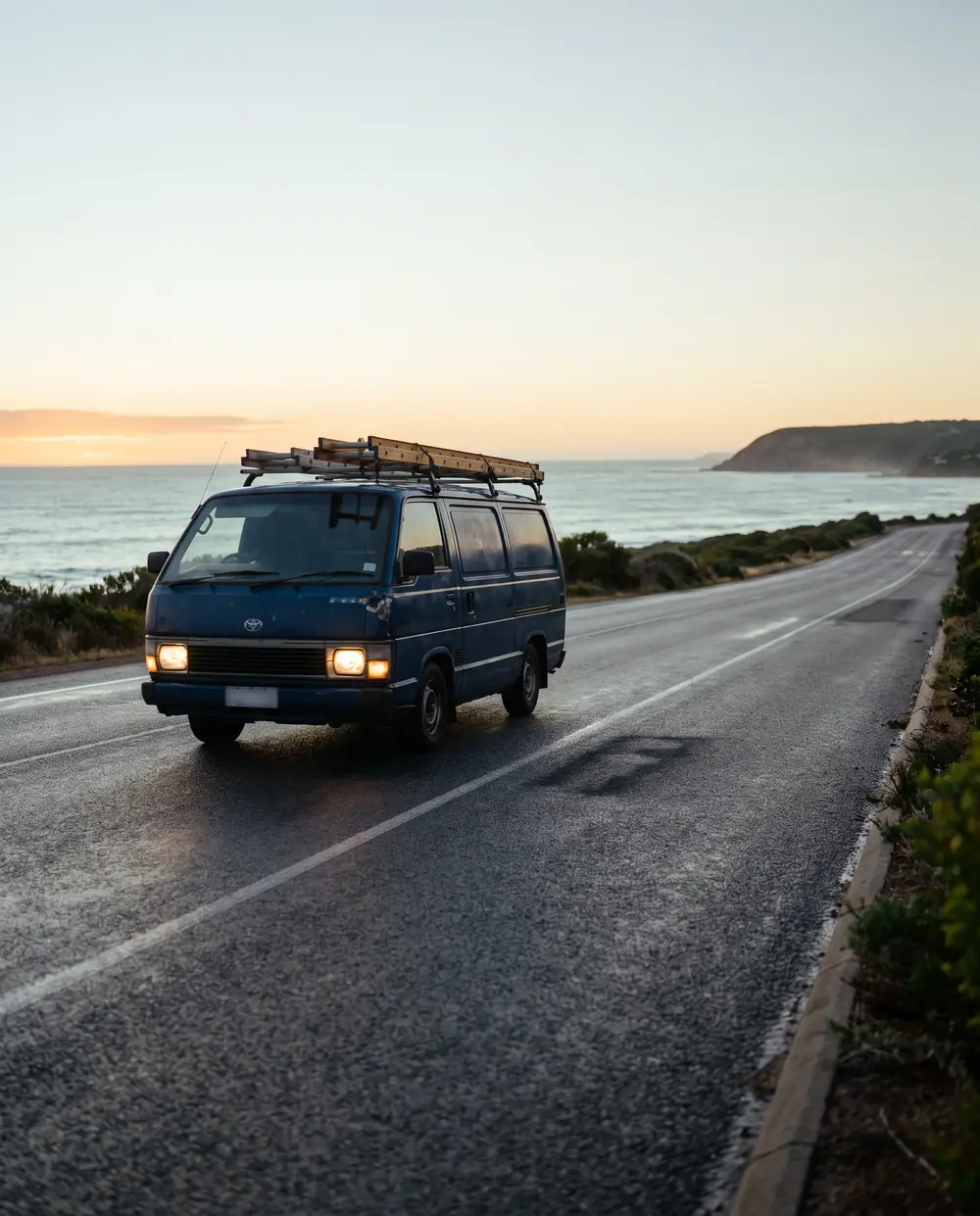 An electrician's van first on the coastal road at dawn
